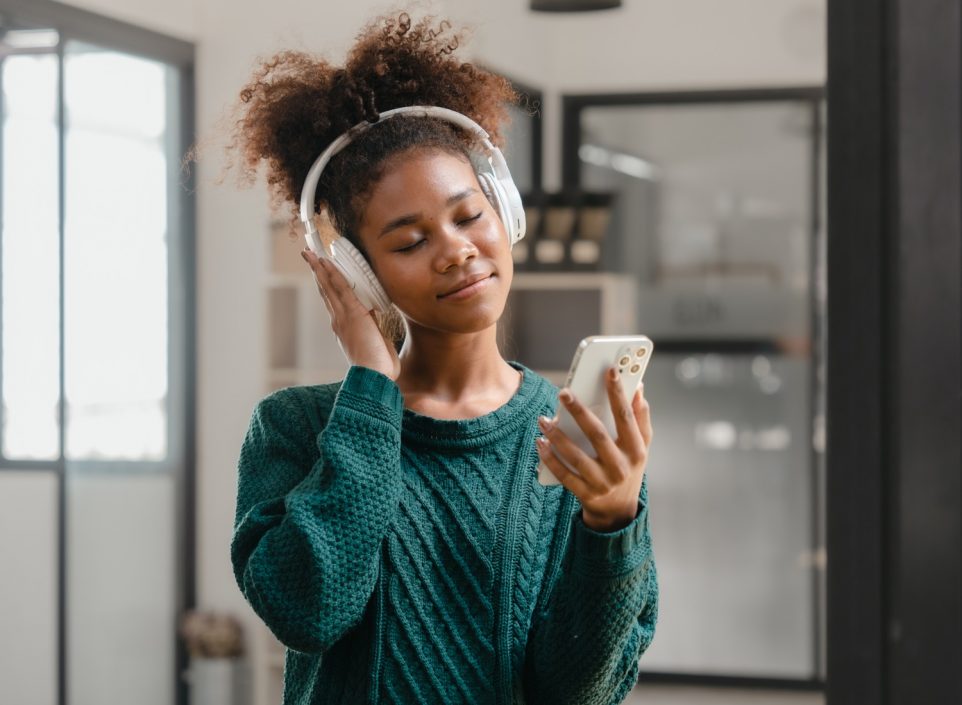 Woman listening to headphones paired with cell phone